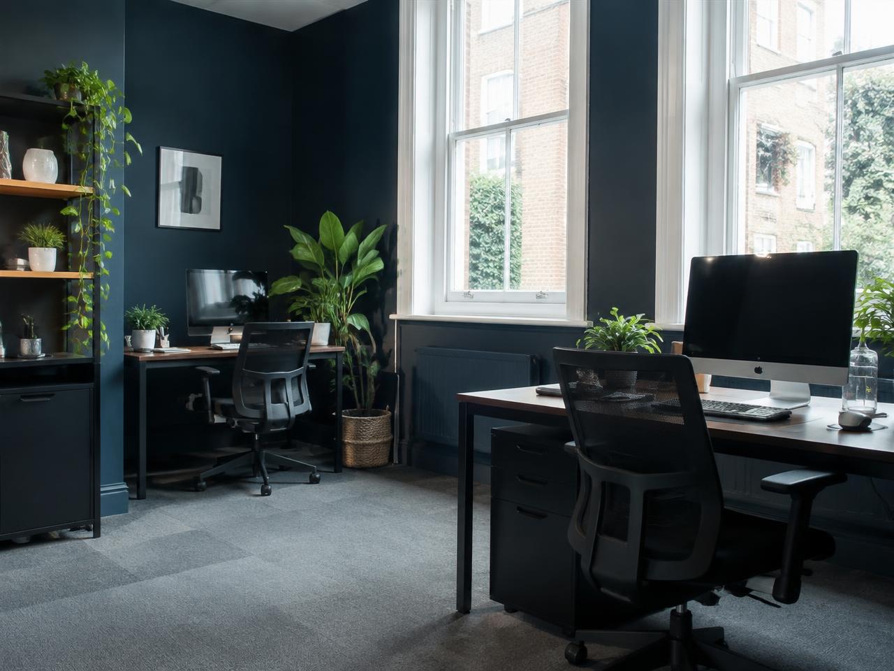Quiet modern office workspace with desks beside large windows
